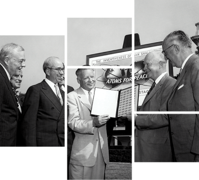 group of well dressed men smilling while gazing at an open document held by two of them